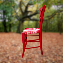 Charger l'image dans la galerie, Chaise paillée ancienne revêtue d'un paillage dans les tons rouges, roses, écru avec une pointe de vert.t Vue côté.