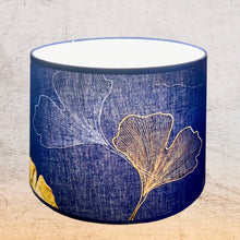 Charger l&#39;image dans la galerie, Abat jour de forme tambour revêtu d&#39;un coton contrecollé. Feuilles de Ginko biloba sur fond marine.
