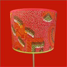 Charger l&#39;image dans la galerie, Abat-jour cylindre contrecollé sur un tissu africain dans les tons rouges, verts.
